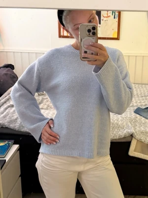 Babyblå stickad tröja - Supermysig babyblå stickad tröja från BikBok med rund hals och långa ärmar. Perfekt att slänga på sig när det är kallt ute! Den är lite nopprig men inget man märker av!