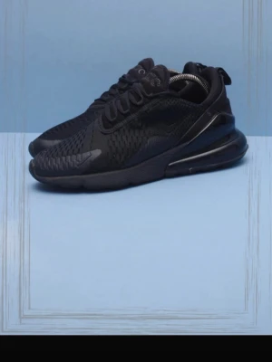 Svarta Nike 270s helsvarta - Säljer ett par helsvarta Nike Air 270s sneakers med mesh- och syntetmaterial. Skorna har en chunky sula med synlig luftbubbla i hälen, snörning och en sportig, modern look. Perfekta för dig som gillar stilrena och bekväma sneakers.