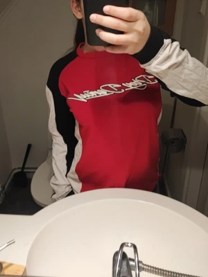 Röd och svart långärmad tröja - Säljer en sportig långärmad tröja i rött, svart och vitt med coolt tryck över bröstet. Snygg och vintage. 