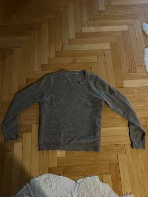 Grå stickad tröja med rund hals - Jag säljer en brun/grå stickad tröja som inte använts så mycket. Perfekt för att ha som ett överplagg och för kalla dagar!