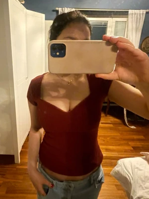 Vinröd ribbad topp - Säljer en vinröd ribbad topp med korta ärmar. Toppen är figurnära och perfekt att matcha med jeans eller kjol. Materialet är stretchigt och bekvämt, vilket gör den enkel att bära hela dagen.