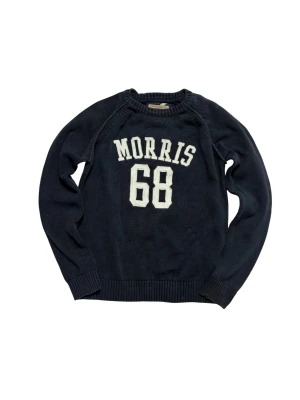 Morris Stickad tröja - Schysst mörkblå stickad tröja från Morris. Tröjan har rund hals, ribbade muddar och gråa armbågslappar på baksidan av ärmarna.                      Hör av dig vid frågor!