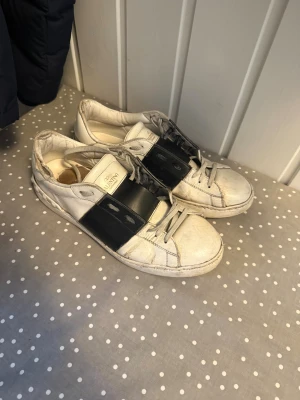 Valentino Garavani vita sneakers - Snygga vita sneakers från Valentino Garavani. Givetvis Äkta! Finns slitningar men inget som stör användningen. Frågor sker i DM. Billigt vid SNABB affär!!! Box medföljer
