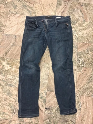 Mörkblåa Replay anbass jeans - Snygga mörkblåa jeans från Replay. Storlek w34 och 32L. Liten slitning i skrevet, se bild nr3. Priset är inte hugget i sten!
