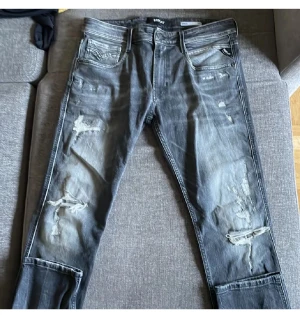 Mörk gråa Replay jeans med slitningar - Säljer ett par tvär feta Replay jeans med slitningar. Trendiga och svåra att få tag på. Storlek 32/32. Vid fler frågor och funderingar är det bara att höra av sig. Pris ej hugget i sten