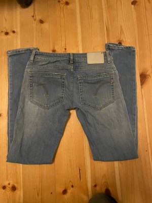 Ljusblå jeans med raka ben - Säljer ett par ljusblå jeans med klassisk design och raka ben. Jeansen har snygga detaljer på bakfickorna och en neutral patch bak i midjan. Perfekta för dig som gillar en enkel och stilren look.