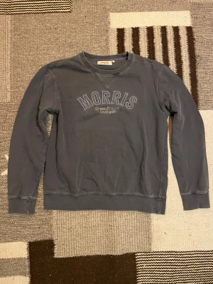 Morris sweatshirt - Ljusgrå sweatshirt från Morris med broderad logga på bröstet. Tröjan är tillverkad i mjuk bomull. Perfekt för chill dagar och enkel att matcha. Hör av dig vid minsta fundering!:)