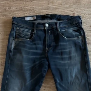 Replay Hyperflex blå jeans med slitning - Säljer ett par Replay Hyperflex jeans i blå tvätt med snygga slitningar. 