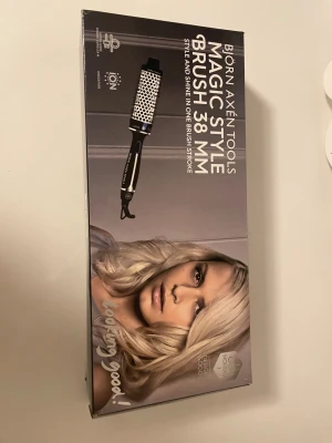 Björn Axén Tools Magic Style Brush 38 mm - Björn Axén Tools Magic Style Brush 38 mm med jonfunktion för styling och glans. Borsten är i mycket gott skick, komplett med originalkartong och strömkabel. Perfekt för att skapa volym och mjuka lockar. Inga synliga defekter eller slitage.