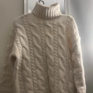 Vit stickad polotröja med flätmönster Bikbok - Säljer en vit polotröja från Bikbok i storlek S. Tröjan är stickad med grovt flätmönster och har en hög, ribbad polokrage. Långärmad och riktigt skön att bära. Den var för stor på mig.