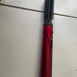 OBH Nordica Type 3543 Varmluftsborste - OBH Nordica varmluftsborste, modell Type 3543, i röd färg. 230V, 250W. Utrustad med roterande borsthuvud och två värmelägen. Synligt i gott begagnat skick. Perfekt för styling och volym till håret.