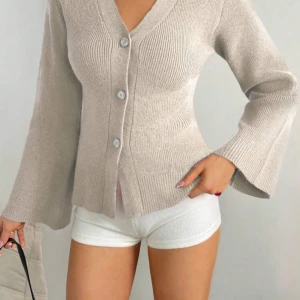 Beige stickad kofta - Jättefin beige stickad kofta med knappar! Jag köpte den men den passade tyvärr inte så därför säljer jag den. Koftan är bara testad men annars helt oanvänd dvs så är den i nytt skick!💕 pris kan diskuteras (köpte den för 289 kr).