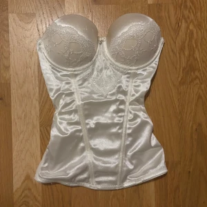 Vit korsett - Vit korsett med spets framtill. Supersöt och perfekt för ex. halloween! Bysten är i storlek 75A. Den har push up i men det går att ta bort om man inte vill ha det