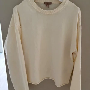 Crèmevit stickad tröja från H&M - En stilren crèmevit stickad tröja från H&M i storlek S. Tröjan har rund halsringning, långa ärmar och en relaxed passform. Perfekt att slänga på sig när det är lite kyligare ute. Enkel och clean look som funkar till det mesta.