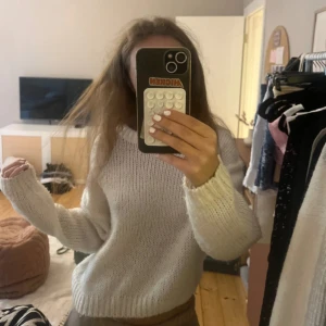 Vit stickad tröja med loose fit - Mysig vit stickad tröja med avslappnad, loose passform och långa ärmar. Tröjan har en enkel rund halsringning och är perfekt för lager-på-lager. Den är stickad i ett mjukt material som känns skönt mot huden.