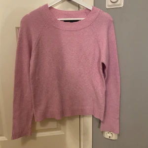 Ljusrosa stickad tröja Vero Moda XS - Superfin ljusrosa stickad tröja från Vero Moda i storlek XS. Tröjan har rund halsringning, ribbade muddar och är långärmad. Perfekt för lager-på-lager och enkel att matcha med jeans eller kjol.