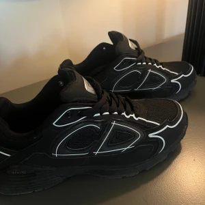 Dior B30 svarta sneakers strl 44 - Säljer ett par svarta Dior B30 sneakers i storlek 44. Skorna har en sportig vibe med mesh och syntetmaterial, coola vita detaljer och reflekterande linjer. Klassisk snörning och chunky sula. Kommer med originalkartong och dustbag. Tecken på användning finns 
