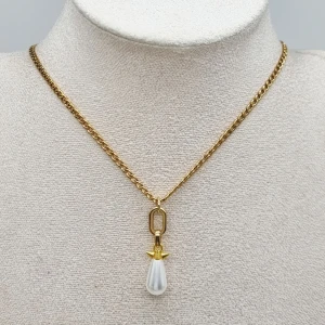 l Handgjort halsband med droppformad pärla - Stilrent halsband i guldton med en kedja och ett hängsmycke i form av en vit, droppformad pärla.