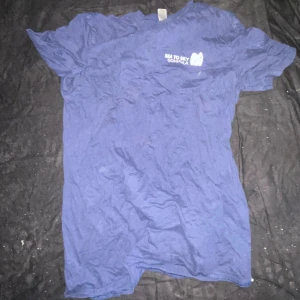 Blå Sea to Sky Gondola t-shirt Gildan - Blå t-shirt från Gildan med Sea to Sky Gondola-tryck fram och coolt gondolmotiv bak. Klassisk passform och rund hals. Tillverkad i mjuk bomull, perfekt för dig som gillar outdoor-vibes och snygga tryck.