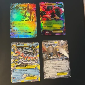 Pokémon EX-kort samling (Lucario, Trevenant, M Glalie, Skarmory) - Fet samling med fyra glittrande Pokémon EX-kort: Lucario, Trevenant, Mega Glalie och Skarmory! Perfekt för dig som vill boosta din samling eller spela med riktigt coola och kraftfulla kort. De 2 längst upp har snygg holo-effekt och alla är i fint skick.