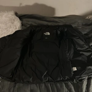 Pufferjacket man The North Face MEDIUM - Knappt använd jacka från north face eftersom jag själv växte ur den men den passar verkligen nästan alla storlekar förutom xl och xs så om man är large passar den och smal. Helt äkta och inga hål eller fel på den. Är välldigt puffig och varm för vintern rekommenderar verkligen. Har en innerficka på vänster sida. Om ni undrar något är de bara och höra av sig och om ni vill ha mer bilder så skriv bara. Den var köpt för 2350 från jd. säljer den på startpris av 1700 men PRISET ÄR INTE HUGGET I STEN!
