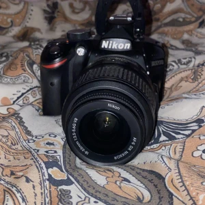Nikon D3200 med 18-55mm objektiv och tillbehör - Nikon D3200 systemkamera med 18-55mm VR-objektiv, laddare och stativ. Kameran är i gott skick med några repor på skärmen, men fungerar utmärkt. Perfekt för både nybörjare och entusiaster. Komplett paket för att komma igång direkt med fotografering. PRISET KAN DISKUTERAS 