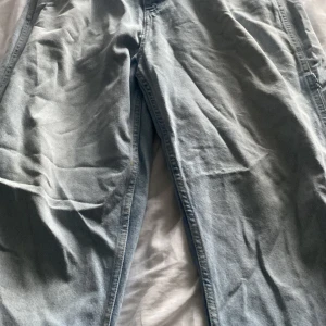 Ljusblå baggy jeans från Karl Kani - Baggy ljusblå jeans från Karl Kani med stora bakfickor och broderad logga på benet. Klassisk denimlook med raka ben och extra fickor på sidorna. Tillverkade i 100% bomull för en skön och avslappnad vibe.