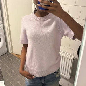 Ljuslila kashmirtröja från COS - Supermjuk och  ljuslila kashmirtröja från COS. Tröjan har korta ärmar och ribbade kanter. Perfekt till jeans eller kjol för en clean men nice look!🌸