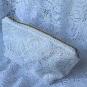 Vit spets necessär/väska stor - Vit spets med guldig dragkedja✨🤍           Mått: 17x13x10cm, på sista bilden ser ni stora modellen jämförd med lilla.                                                 Produkten är av helt återanvänd textil, för miljöns skull♻️                                                       Pris: 199kr +frakt