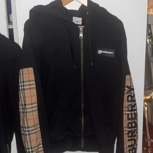 Burberry kofta - Äkta burberry kofta, i använt skick. Pyttelite slitage i texten, men inget som syns. Storlek XS men sitter nästan på M.