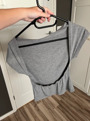 Topp med öppen rygg - Superskön grå topp med öppen rygg. Storlek S, knappt använd. 💕💘