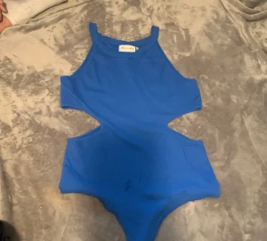 Blå bodysuit - Fin blå bodysuit💙 med cutout vid midjan. Har aldrig använts, helt ny i perfekt form 👌👌 I storlek- L. 