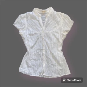 Vit skjorta med guldiga ränder - En vit skjorta som har randiga gulddetaljer. Fint skick! 