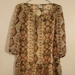 Bohemisk klänning i skirt tyg med underklänning - Supersöt klönning!! Paisleymönstrad i beige, rosa och brunt. Halvtransparent med beige underklänning. Från Vero Moda.  Använd men i gott skick 🤗
