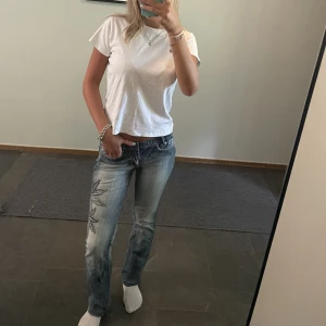 Unika utsvängda jeans - Unika utsvängda vintage jeans med blommor på vänstra benet. De är i perfekt längd för mig som är 165  cm. Jag brukar ha storlek 26 i midja och dessa sitter perfekt. (Billigare frakt genom ”köp nu”)