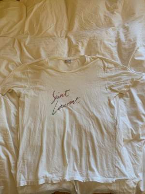 Oversized T-shirt från saint Laurent köpt på abcd i Göteborg för ca 4000kr. T-shirten är tunn och passar perfekt i sommar. Det finns ett par svarta prickar på den och ett par små hål, men inget som märks om man inte kollar väldigt noga. Säljs för 650kr 