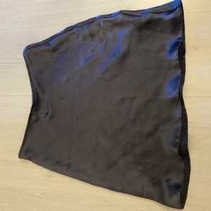 Marinblå siden kjol - Marinblå kort sidenkjol med resår i midjan. Modellen är petite