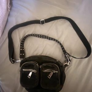 Noella väska - Svart Noella väska i mindre modell, något använt skick. Mestadels legat i garderoben (så den har blivit något matt i färgen men ser ut som att det borde gå bort i tvätt), annars fin och mycket att ge.