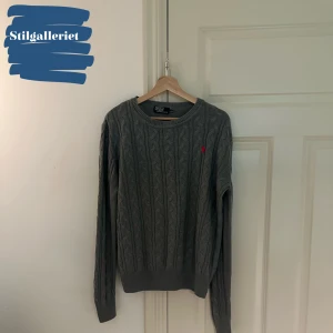 Ralph Lauren tröja - En Väldigt fin stickad grå polo Ralph Lauren tröja. Skicket på tröjan är 9/10, inga difekter. Storleken är M/L Kontakta vid minsta lilla fråga eller fundering.