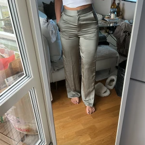 Silkesbyxor i grön med slits från H&M  - Silkesbyxor i grön med slits från H&M. Helt oanvända och prislapp kvar. 