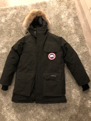Canada Goose Expedition Parka - Cond: 9/10 Köpt 2018 på Johnells i kungens kurva. Använd en vinter.  Nypris idag 22 000 kr. Storlek xs men denna modellen är stor i storleken så sitter som M.