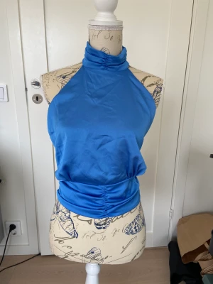 Topp - Blå topp med bar rygg. Bara buren en gång så väldigt bra skick. Eftersom man kan knyta själv kan den passa flera olika storlekar. Skriv om fler bilder eller frågor!💗