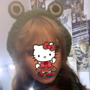 Hatt - Stickad Grod hatt som jag aldrig använt. Den e gullig i min åsikt. Kommer ej ihåg vart den är ifrån. Sitter bekvämt 