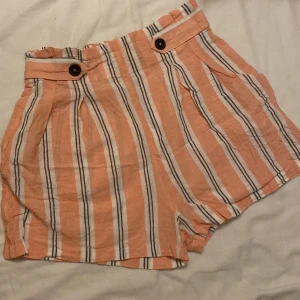 Linne-shorts från Stradivarius  - Säljer denna sköna linne-shorts från Stradivarius. Storlek M, passar som S. I fint skick. Resårband baktill. Fake-knappning. Randig. 