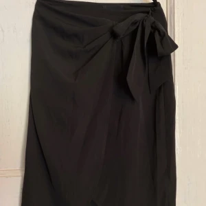 Svart omlottkjol - Svart omlottkjol med dragkedja. Använd fåtal gånger. Strl xs