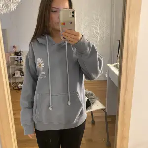 Säljer denna blå hoodie från pull&bear med blomma och text litet fram och stort bak på ryggen. Köpare står för frakt