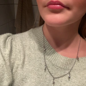 Halsband blixtar  - Ett silvrigt halsband med små söta blixtar på. Aldrig använt 