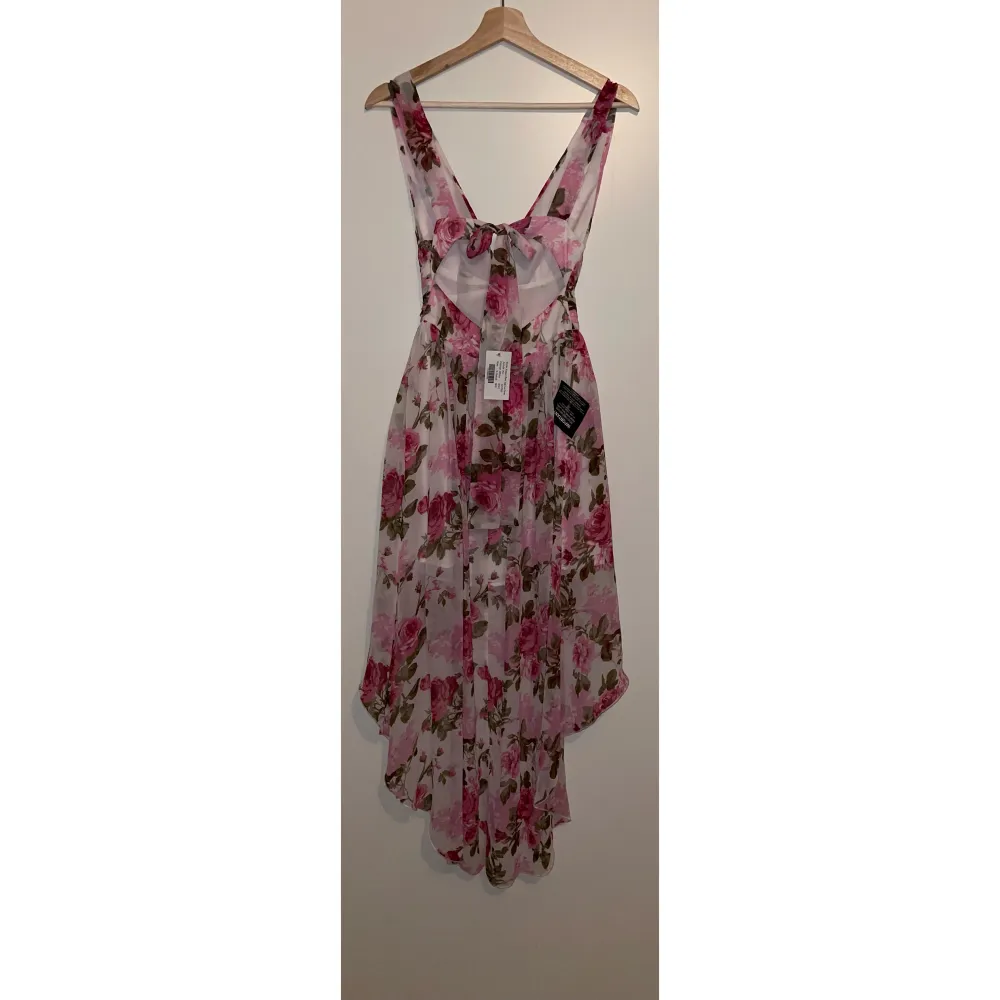 Floral High Low Dress från Nelly, stl. XS.  Helt ny, har lapparna kvar.   Nypris: 499 kr. Köp pris: 150 kr.  Finns att hämta upp i centrala Örebro. Köparen står för frakt om post önskas.. Klänningar.