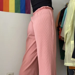 Kostymbyxor XS-M - Plisserade kostymbyxor i ROSA!! Passar perfekt nu när Barbie tagit världen med storm. Sitter underbart och är väldigt luftiga och sköna. Något genomskinliga, men har man en neutral färg på sina underkläder är det inget som märks. Passar XS-M. 
