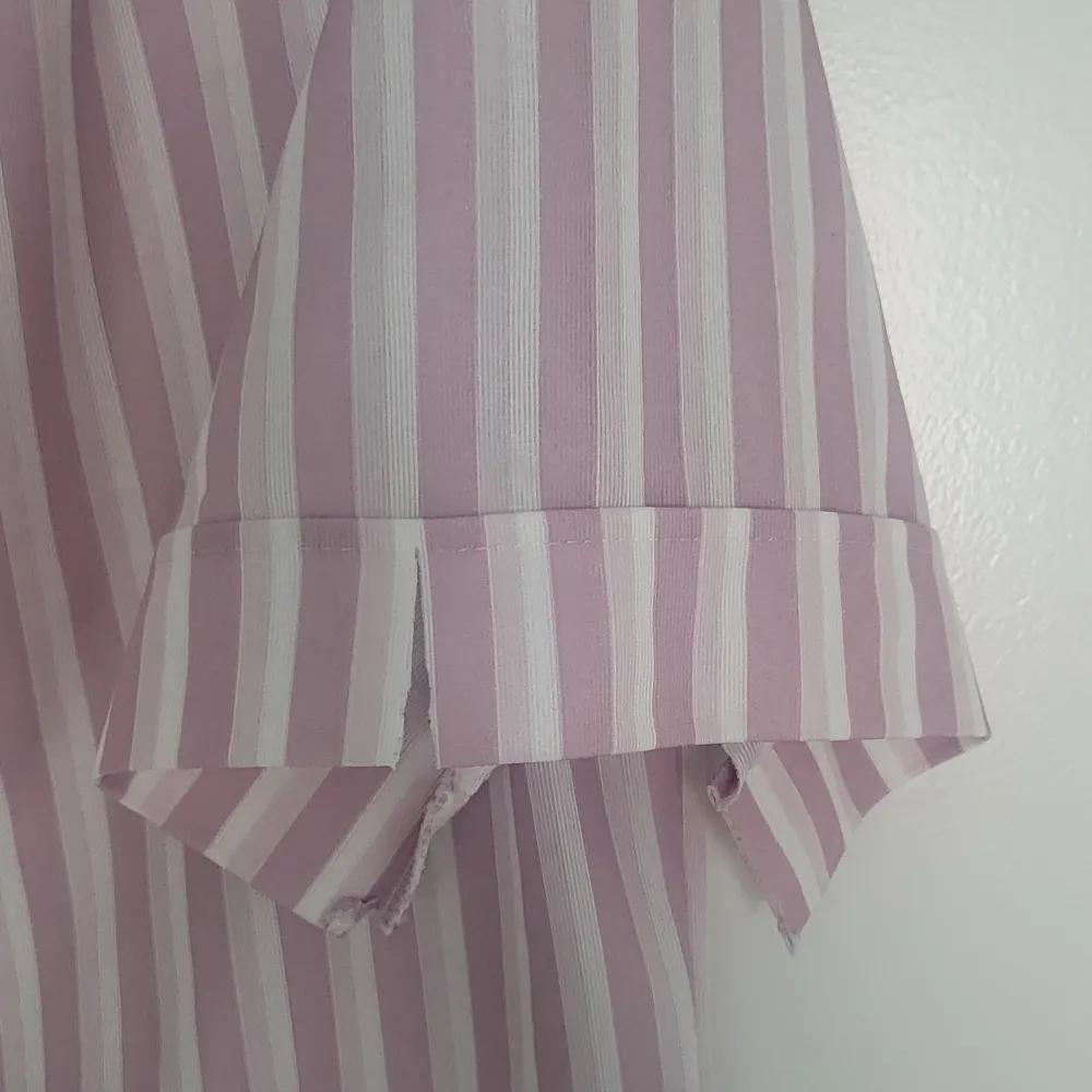 Randig rosa/vit tunn blus med dekorativa klipp i ärmslut. Blusar.